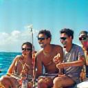 Group of friends laughing and enjoying a fishing trip with AquaGlimmer